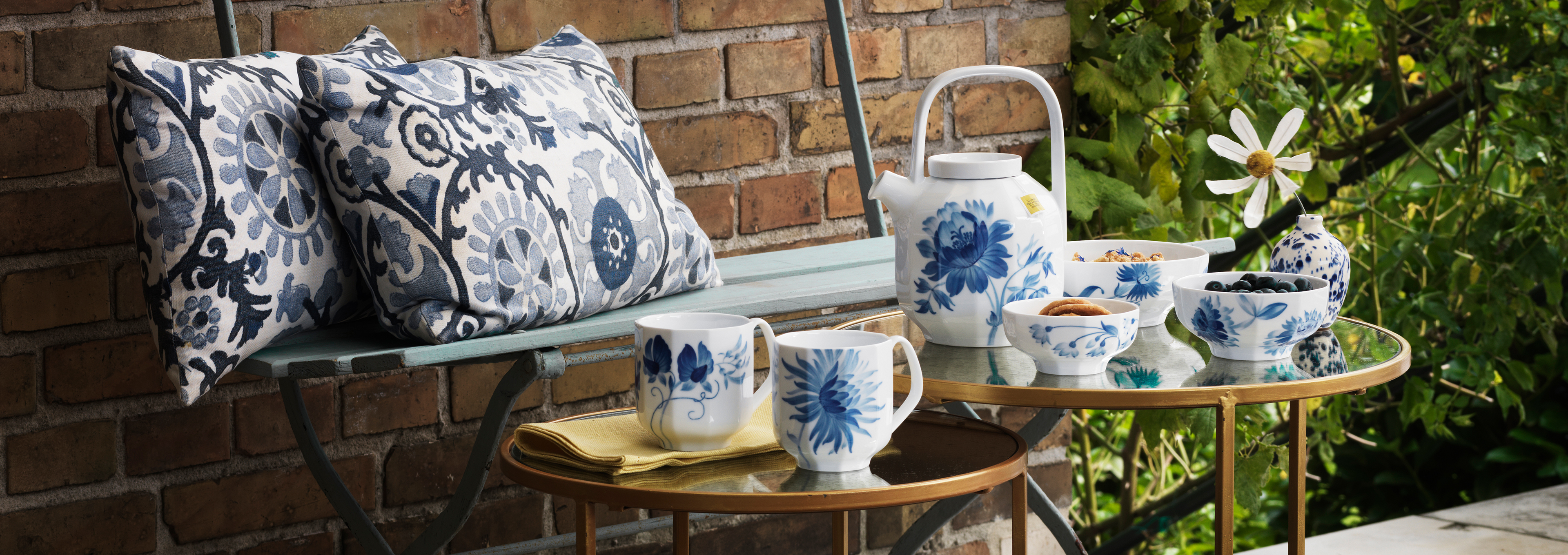 Garden table around tea time set with blomst teapot and mugs plus a blomst bowl with sweets